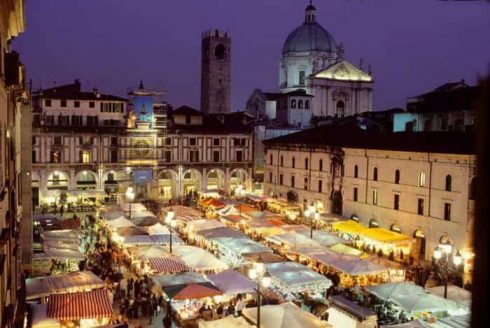På Piazza della Loggia finner du det ukentlige lørdagsmarkedet. Her fra festen Fiera Faustino. Duomo Nuovo til høyre bak. Foto: © Brescia Turismo Brescia, Lombardia, Nord-Italia, Italia