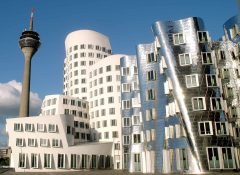 Frank Gehrys bygninger i Düsseldorfs moderne MedienHafen, med Rhein-Turm i bakgrunnen. Foto: © Düsseldorf Marketing & Tourismus GmbH Media-Hafen, Frank Gehry, Düsseldorf, Nordrhein-Westfalen, Vest-Tyskland, Tyskland
