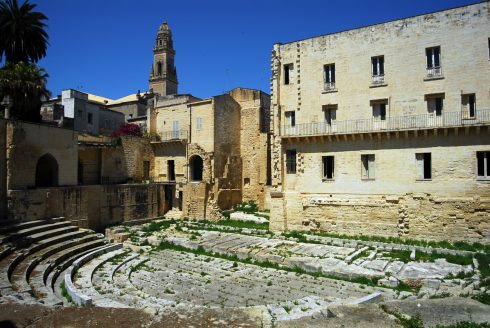 Teater fra romertid, omgitt av lag på lag med arkitektur og Lecces duomos klokketårn i bakgrunnen. Teater, romertid, Lecce, Puglia, Sør-Italia, Italia
