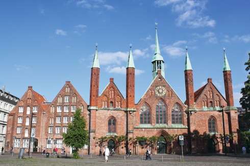 Heiliger-Geist-Hospital er Europas mest komplette i sitt slag, og har smale, spisse tårn som strekker seg mot himmelen på den vakre gotiske fasaden. Heiliger-Geist-Hospital, Hansestadt Lübeck, Schleswig-Holstein, Hansaforbundet, Unesco Verdensarv, Altstadt, Historisk, Middelalder, Markt, Nord-Tyskland, Tyskland