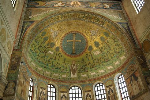 Hvelvet i apsiden er dekorert med mosaikker i vakre farger. I midten troner Sant Apollinaris, Ravennas første biskop. Foto: Berthold Werner/Wikipedia Hvelvet i apsiden er dekorert med mosaikker, Sant Apollinaris, Ravennas første biskop, Unesco, Ravenna, Emilia-Romagna, Nord-Italia, Italia