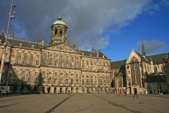 Det kongelige slott ligger i Amsterdam sentrum ved plassen De Dam i enden av Aveny Damrak. 1400-tallskirken De Nieuwe Kerk til høyre Det kongelige slott, Amsterdam, kanaler, Unescos liste over Verdensarven, Nederland