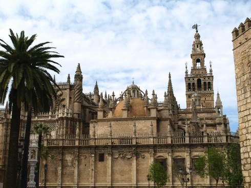 La Giralda er navnet på tårnet som en gang tilhørte en minaret, som på 1400-tallet ble inkorporert i den gotiske katedralen Catedral de Santa María de la Sede, i forgrunnen. La Giralda, Sevilla, Catedral de Santa María de la Sede, Guadalquivir, Unescos liste over Verdensarven, historisk bydel, gamleby, Andalucia, Spania