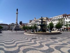 Plassen Rossio rett ovenfor Lisboas sentrum Baixa er vakkert stensatt. Legg merke til heistårnet Elevador de Santa Justa til høyre for søylen Lisboa, elven Tajo, Baixa, historisk, Alfama, gamlebyen Bairro Alto, Belém, Unescos liste over Verdensarven, Midt-Portugal, Portugal
