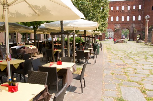 En av Torinos mange restauranter med utendørs servering. Her ved Porta Palatina fra romertiden på Piazza Augusta, et steinkast fra Piazza Castello. Torino, Valle d'Aosta og Piemonte, Unescos liste over Verdensarven, barokk-arkitektur, Nord-Italia, Italia