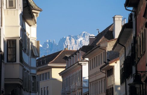 Bolzano er omgitt av Dolomittenes høye fjell, som skaper en dramatisk bakgrunn for gamlebyens bebyggelse. Foto: Laurin Moser/ Alto Adige Marketing Bolzano, Bozen, Altstadt, Alto Adige, Nord-Italia, Tyrol, Italia