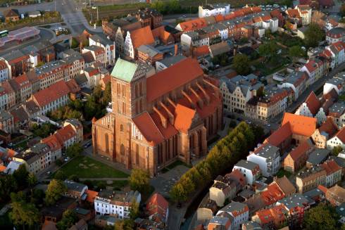 Flyfoto av den enorme gotiske kirken St. Nikolai, som kom relativt uskadet fra bombetoktene under Den andre verdenskrigen. Foto: © TZW / Hansestadt Wismar St. Nikolai Kirche, Wismar, Østersjøen, middelalder, Backsteinsgotik, Ostsee, Unesco Verdensarv, Gamlebyen, Altstadt, Hansestadt Wismar, Mecklenburg Vorpommern, Nord-Tyskland