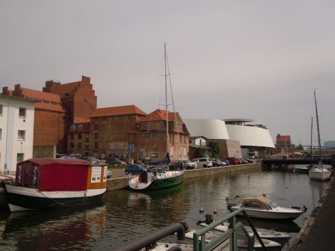 Mellom gamlebyen og havneområdet er det en kanal. I bakgrunnen akvariet Ozeaneum. Foto: © reisdit.no Havnen, Ozeaneum, Stralsund, middelalder, Backsteinsgotik, Ostsee, Unesco Verdensarv, Gamlebyen, Altstadt, Hansestadt Wismar, Mecklenburg Vorpommern, Østersjøen, Nord-Tyskland