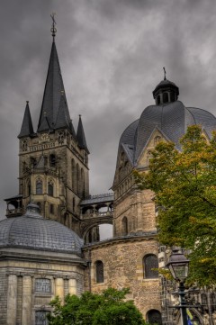 Aachener Dom med det oktongonale (åttekantede) kroningskapellet Pfalzkapelle til høyre. Legg merke til gangbroen fra vestverket til Pfalzkapelle Aachen, Kaiserpfalz, Pfalzkapelle, Karl den Store, pilegrimsmål, karolingisk romansk arkitektur, tidlig middelalder, tidlig kristendom, skattkammeret, klosterhage, Unescos liste over Verdensarven, Vest-Tyskland