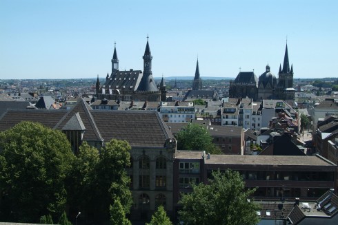 Aachens bysilhuett er lett gjenkjennelig, med tårnene til det gamle rådhuset til venstre og domkirkekomplekset til høyre. Foto: © Andreas Herrmann / ats Aachen, Kaiserpfalz, Pfalzkapelle, Karl den Store, pilegrimsmål, karolingisk romansk arkitektur, tidlig middelalder, tidlig kristendom, skattkammeret, klosterhage, Unescos liste over Verdensarven, Vest-Tyskland