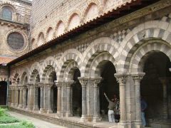 Søylegangen rundt den vesle klosterhagen, hvor det ble dyrket krydderurter og nyttevekster, er vakker med sine tofargede arkadebuer. Foto: © reisdit.no Le Puy en Velay, Cathédrale de Notre-Dame, pilegrimsmål, romansk arkitektur, tidlig middelalder, tidlig kristendom, sort madonna, klosterhage, Unescos liste over Verdensarven, Massif Central, Sør-Frankrike