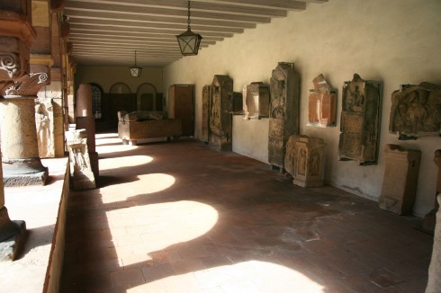 I klostergangen er det stilt ut gravsteiner fra romertiden sammen med sarkofager - legg merke til søylekapitelet helt til venstre - deler av bygningen er i romansk stil fra 1.000-tallet. Foto: © reisdit.no Worms, Rhinen, Mainz, Kaiserdom, Dom St. Peter, jødene, Heiliger Sand, synagoge, Mikwah, romansk arkitektur, Kaiser, Kurfyrster, romertid, middelalder, renessanse, barokk, Speyer, Mainz, Vest-Tyskland