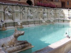 Fonte Gaia på Piazza del Campo er vakkert dekorert - blant annet med ulvinner. Foto: Marcus Mark / Wikipedia Siena, Unescos liste over Verdensarven, historisk, etruskere, middelalder, gamleby, romensk, gotisk, katedral, Toscana, Midt-Italia, Italia