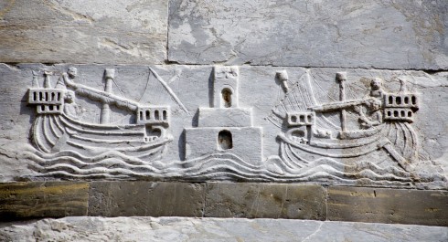 Et relieff på duomos vegg, som mer enn antyder hvordan det enorme byggeprosjektet ble finansiert; gjennom krigsbytte fra sjøslaget der sarasenere ble beseiret utenfor Palermo i år 1063. Pisa, pisansk romansk, arkitektur, middelalder, renessanse, Arno, Campo dei Miracoli, katedral, baptisteria, kampanile, Unescos liste over Verdensarven, historisk bydel, museer, gamleby, etruskerne, Toscana, Midt-Italia, Italia